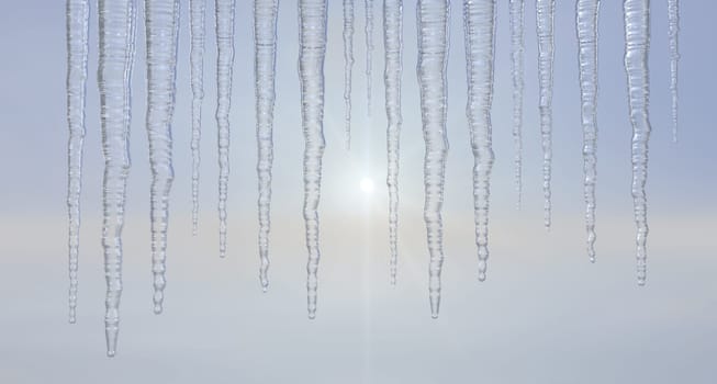 Icicles hanging outside against a hazy sky