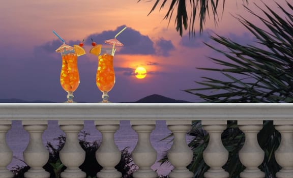 Two tropical drinks on a balcony with a tropical sunset in the background