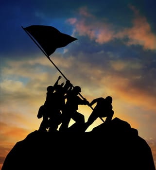 Silhouette of the image of soldiers raising the flag at Iwo Jima against a colorful sunset with clipping path