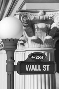 Black and white image of a Wall Street sign post in front of rows of Corinthian columns