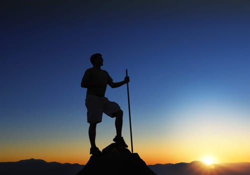 Man at the top of a mountain range at sunrise