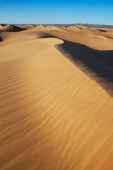 Sahara desert sand dunes with clear blue sky at Erg Lihoudi, M&#039 hamid, Morocco.