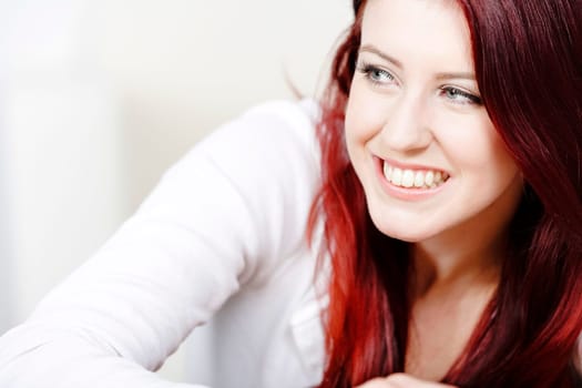 Beautiful young woman resting on a coffee table in front of sofa at home.