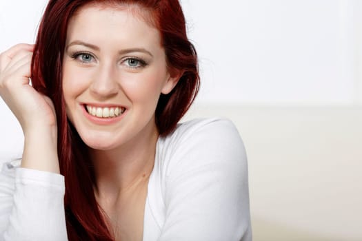 Beautiful young woman resting on a coffee table in front of sofa at home.