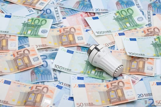 Heating costs concept - thermostatic valve and money