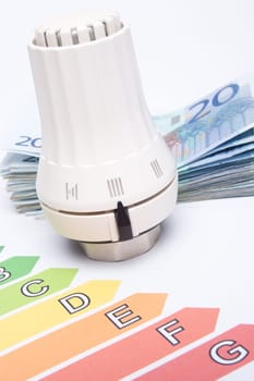 Heating costs concept - thermostatic valve, money and energy efficiency rating.