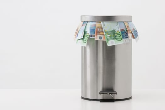 Money concept - throw money into waste bin. Unreasonable using of money.