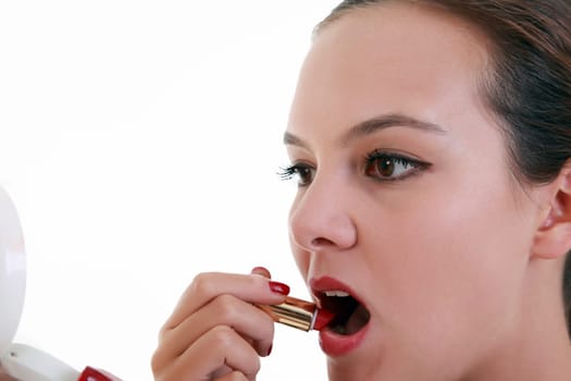 Young woman applying red lipstick and mirror
