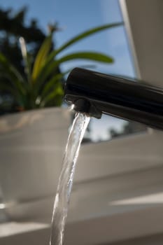 Chromed faucet is opened and release water stream