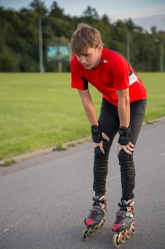 Young sportsman on roller is tired and thoughtful