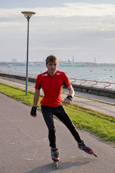 Young sportsman is taking ride on roller skates
