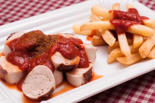 Curry sausage with sauce and French fries with ketchup