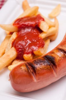 Close-up grilled red sausage and french fries