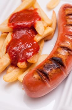 Close-up grilled red sausage and french fries