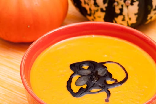 Close-up pumpkin soup with pumpkin seed oil and pumpkin seeds