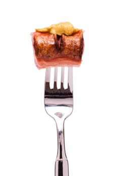 White insulated red sausage with mustard on a fork