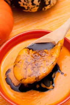 Spoon with pumpkin cream soup and pumpkin seed oil