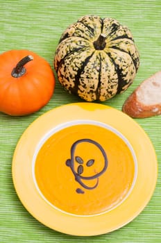 Pumpkin soup and pumpkin seeds in yellow plate
