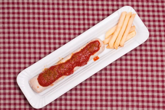 Currywurst and French fries on checkered cloth