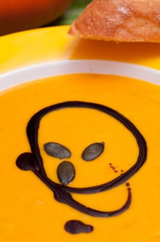 Pumpkin soup in orange and a slice of bread