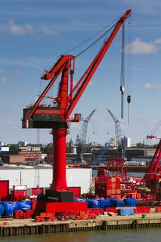 Big red crane in port on sunny day with blue sky background