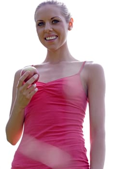 Beautiful young woman eating an apple on a summers day in the countryside.