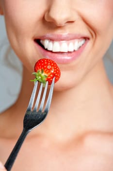 Beautiful young woman eating fresh summer berries