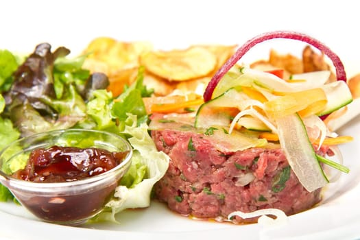 raw ground beef with chips and salad