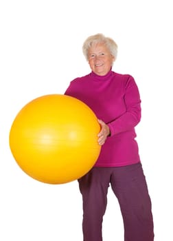 Happy overweight retired woman holding a yellow pilates or gym ball in her hands isolated on white