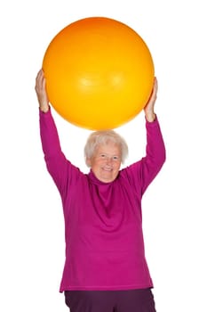 Cheerful overweight senior woman exercising with a gym ball doing pilates exercises lifting the ball above her head to improve muscle control