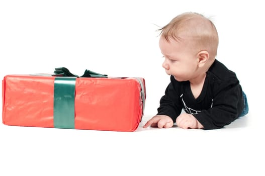 Beautiful baby boy watching on christmas present on white