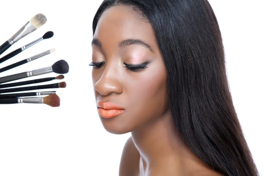 Closeup portrait of a young African beauty and make up brushes