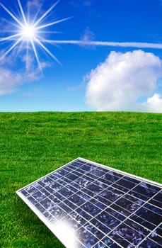 Solar energy panel against blue sky and grass