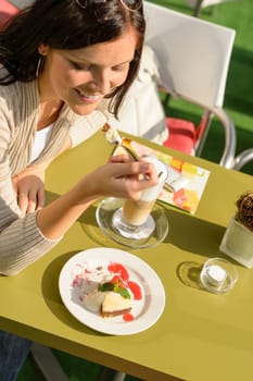 Woman eating cheesecake at cafe bar happy smiling restaurant dessert