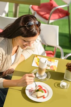 Woman eating cheesecake at cafe bar happy smiling restaurant dessert