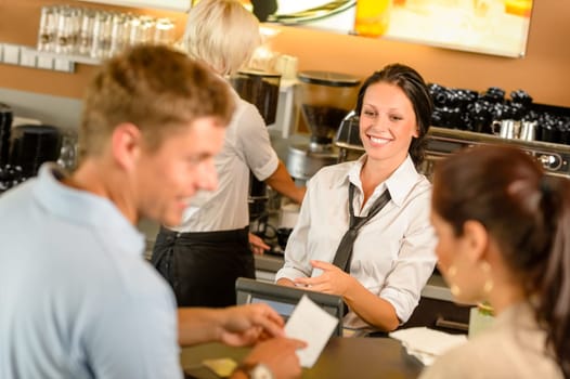 Couple paying bill at cafe cash desk smiling waitress bar