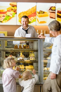 Grandchildren asking grandmother for cakes at cafe dessert appetite restaurant