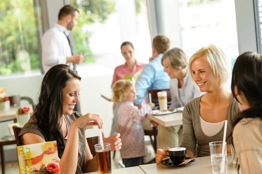 Women friends enjoying a drink at cafe talking happy relaxing