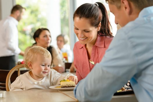 Mother and father with child eating cake woman man cafe