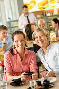 Mother and daughter relaxing in a cafe women restaurant happy