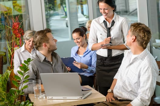 Waitress taking order from businessmen in cafe smiling laptop work