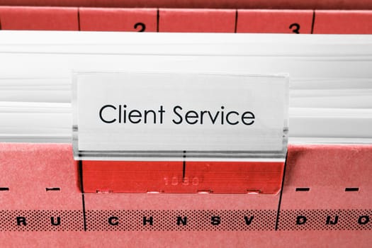 red hanging file folder labeled with client service