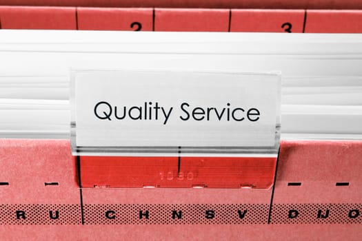 red hanging file folder labeled with quality service