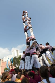 BARCELONA - SEPTEMBER 11: Some unidentified people called Castellers do a Castell or Human Tower, typical tradition in Catalonia, on September 11, 2012 in Barcelona, Spain.