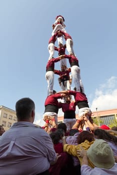 BARCELONA - SEPTEMBER 11: Some unidentified people called Castellers do a Castell or Human Tower, typical tradition in Catalonia, on September 11, 2012 in Barcelona, Spain.
