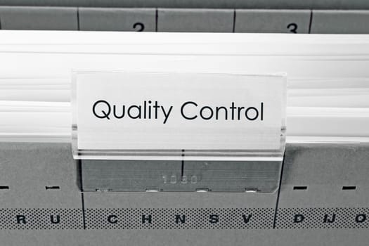 grey hanging file folder labeled with Quality Control