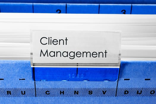 blue hanging file folder labeled with Client Management