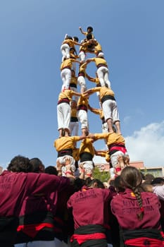 BARCELONA - SEPTEMBER 11: Some unidentified people called Castellers do a Castell or Human Tower, typical tradition in Catalonia, on September 11, 2012 in Barcelona, Spain.