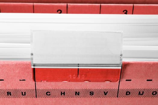 red hanging file folder with blank label