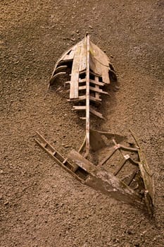 boat ship skeleton grunge half buried in brown sand